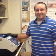 Alejandro Lopez-Ceron stands next to his lab bench.